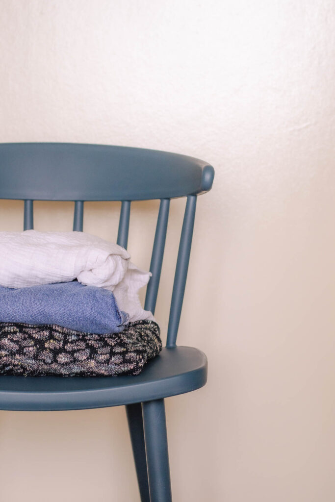 A blue chair with a white blouse, blue jeans, and sweater